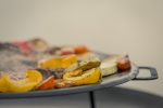 MUURIKKA tērauda panna uz statīva tiek izmantota cepot dārzeņus un gaļu uz ugunskura vietas