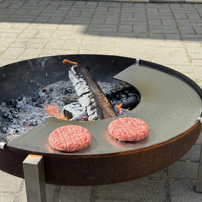 Burgeru gaļas grillēšana uz nerūsējoša tērauda gatavošanas virsmas ugunskuram